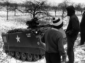 Village youth examines US armoured personnel carrier during German-American manoeuvre "Silberkralle"