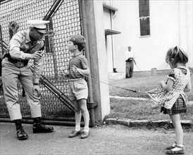 Two little children speak with a U.S. soldier in Germany