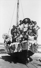 Eine Badegesellschaft von Frauen und Mädchen in Badekleidung posiert am Strand der Ostsee auf einem