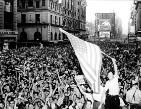Flaggeschwenkend und winkend feiern die Amerikaner am 15. August 1945 in New York das Ende des