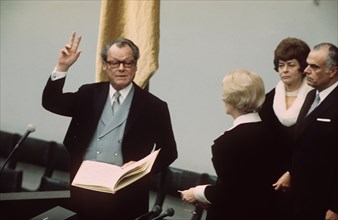 Old and new chancellor Willy Brandt (l) raises his hand to swear his oath as chancellor on the 14th of December in 1972