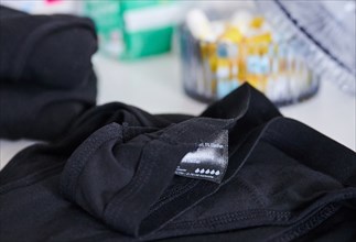 The label of period underwear symbolically depicts five drops for strong absorbency. (posed scene)