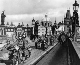 Die deutsche Wehrmacht marschiert in Prag ein. Die bewaffneten Soldaten fahren mit Motorrädern über