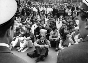 Sit-down strike demonstrators being watched by police officers in front of the town hall Schöneberg in Berlin on 2nd June 1967
