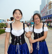 Two women wear Bavarian Dirndl at 24th Oktoberfest in Qingdao, China, 16 August 2014