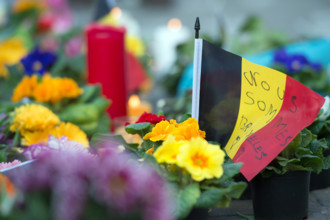 "Nous sommes Bruxelles" (We are Brussels) is written on a small belgian flag next to flowers and