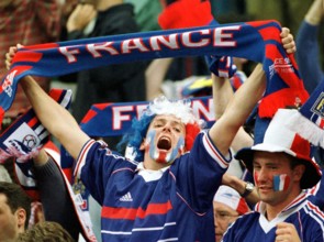 A French supporter holds up his fan scarf and frenetically cheers on his team during the World Cup