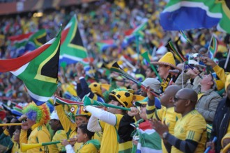 Fans celebrate during the opening ceremony of the 2010 FIFA World Cup at Soccer City stadium in