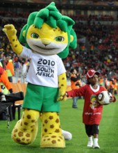 Zakumi, the official World Cup mascot walks hand in hand with a small girl on the pitch prior to