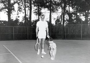 Mohammad Reza Shah Pahlavi introducing his son to the joys of playing tennis