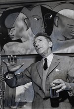 Cocteau devant une tapisserie d'Aubusson réalisée d'après une de ses toiles (1955)