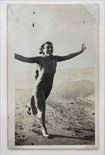 “Donna che corre sulla spiaggia con braccia aperte"