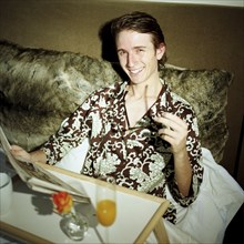 Young Man Having Breakfast in Bed