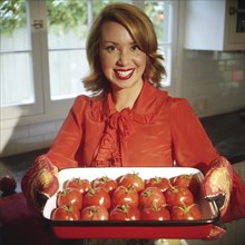 Homemaker Holding Tray of Tomatoes
