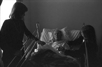 Woman and Girl Visiting Elderly Man in Hospital
