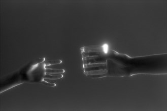 Hands Passing Glass of Water