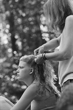 Mother Braiding Daughter's Hair