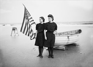 Portrait of Two Young Women with American Flag and Row Boat on Beach, Atlantic City, New Jersey, USA, Detroit Publishing Company, 1900