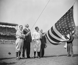 New York Yankee Manager Joe McCarthy, Postmaster General James A. Farley, Washington Senator's Manager Bucky Harris, and Clark Griffith, owner of Senators, Raising Flag before First Baseball Game of S...