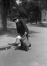 Sanitation Worker Picking up Trash in Street, USA, Harris & Ewing, 1921