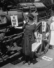 Woman Hanging "No More War" Signs on Military Artillery, USA, Harris & Ewing, 1922