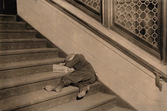 Young Newsboy Sleeping on Stairs with Newspapers, Jersey City, New Jersey, USA, Lewis Hine, 1912