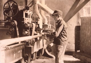 Young Boy Taking Boards away from Double Cut-Off Machine at Lumber Mill, Peru, Indiana, USA, Lewis Hine, 1908