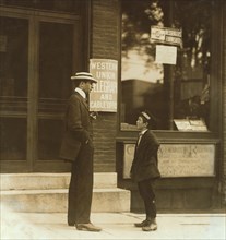 13-year-old Western Union Messenger Boy Talking to Man outside Office, Usually Works from Noon to 10:30pm, Burlington, Vermont, USA, Lewis Hine, 1910