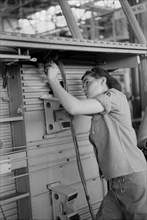 Female Worker Installing Electric Wiring in Fuselage, Vultee Aircraft Company, Nashville, Tennessee, USA, Jack Delano for Office of War Information, August 1942