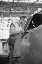 Worker Riveting a Fuselage on a Sub-Assembly Line, Vultee Aircraft Company, Nashville, Tennessee, USA, Jack Delano for Office of War Information, August 1942