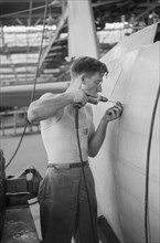 Worker Drilling Holes for Rivets in a Fuselage on a Sub-Assembly Line, Vultee Aircraft Company, Nashville, Tennessee, USA, Jack Delano for Office of War Information, August 1942