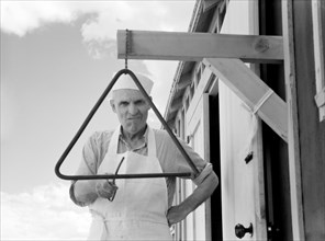 Chef Ringing Dinner Chime, Rimrock Camp in Central Oregon Land Development Project, Jefferson County, Oregon, USA, Arthur Rothstein for Farm Security Administration, June 1936