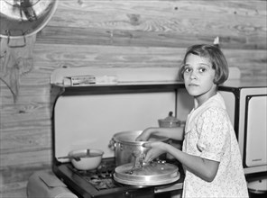 Young Girl Cooking While Parents Work at Citrus Packing Plant, Winterhaven, Florida, Arthur Rothstein for Farm Security Administration, January 1937
