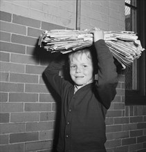 Boy Bringing Load of Scrap Paper to School during Scrap Salvage Campaign, Victory Program, Washington DC, USA, Marjorie Collins for Office of War Information, May 1942