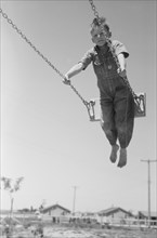 Boy on Swing, Farm Security Administration (FSA) Labor Camp, Caldwell, Idaho, USA, Russell Lee, June 1941