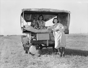 Migrant Family Heading to Arkansas Delta for Work in Cotton Fields, with Flat Tire, Texas, USA, Dorothea Lange for Farm Security Administration, August 1936