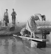 Oklahoma Migratory Workers Washing in Hot Spring in Desert, Imperial Valley, California, USA, Dorothea Lange for Farm Security Administration, March 1937