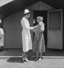 Resident Nurse Visiting a Sick Child, Farm Security Administration (FSA) Camp, Farmersville, Tulare County, California, USA, Dorothea Lange for Farm Security Administration, May 1939