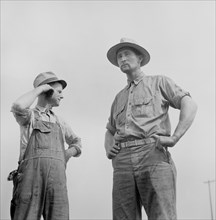 Soldier, who was Granted Furlough to help with Harvesting, and Farmer Watching Threshing on Farm, Jackson County, Michigan, USA, Arthur S. Siegel for Office of War Information, September 1941
