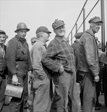 Workers Lining up Before Time Clock, Bethlehem-Fairfield, Shipyards, Baltimore, Maryland, USA, Arthur S. Siegel for Office of War Information, May 1943