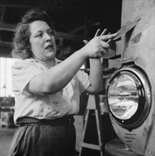 Female Cleaner Scraping Paint from Bus that will be Repainted at Greyhound Garage, Pittsburgh, Pennsylvania, USA, Esther Bubley for Office of War Information, September 1943