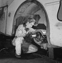 Mechanic Fixing Wheel Axle of Greyhound Bus at Garage, Knoxville, Tennessee, USA, Esther Bubley for Office of War Information, September 1943
