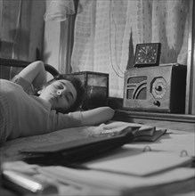 Young Woman Sleeping While Listening to Radio in Boardinghouse Room, Washington DC, USA, Esther Bubley for Office of War Information, January 1943