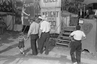 Group of Men and Children at Midway and Carnival, Shelby County Fair and Horse Show, Shelbyville, Kentucky, USA, Marion Post Wolcott for Farm Security Administration, August 1940