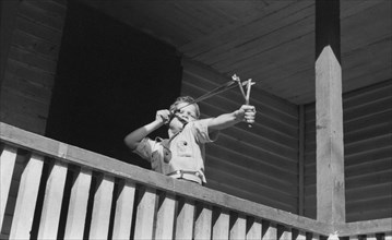 Young Boy Shooting Slingshot from Porch, near Buckhorn, Kentucky, USA, Marion Post Wolcott for Farm Security Administration, September 1940