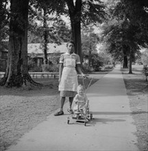 Housekeeper Pushing Young Girl on Toy Cart on Sidewalk, Port Gibson, Mississippi, USA, Marion Post Wolcott for Farm Security Administration, August 1940