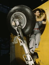 Female Worker Making Final Adjustments in Wheel Well of Inner Wing Before Installation of Landing Gear, Vultee "Vengeance" Dive Bomber, Nashville, Tennessee, USA, Alfred T. Palmer for Office of War In...