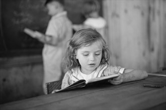 Young Girl Reading Book in Classroom, Cumberland Mountain Farms, near Scottsboro, Alabama, USA, Carl Mydans for U.S. Resettlement Administration, June 1936