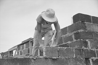 Construction Worker Working with Cinder Blocks in Model Community Planned by Suburban Division of U.S. Resettlement Administration, Greenbelt, Maryland, USA, Carl Mydans for U.S. Resettlement Administ...