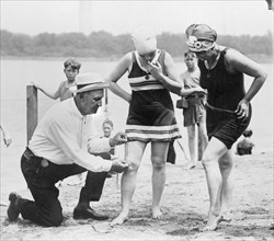 Bill Norton, Bathing Beach "Cop", Using Measuring Distance Between Woman's Knee and Bottom of Bathing Suit at Beach, Washington DC, USA, National Photo Company, 1922